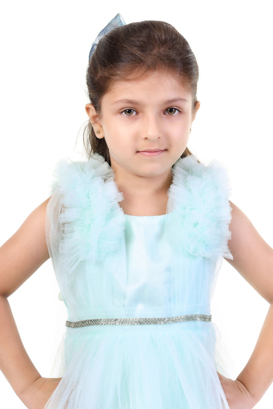 Young girl wearing a mint color dress with ruffled details on a white background