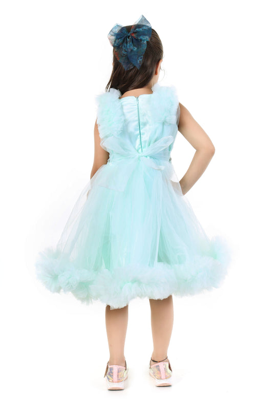 Young girl wearing a mint color dress with ruffled details on a white background