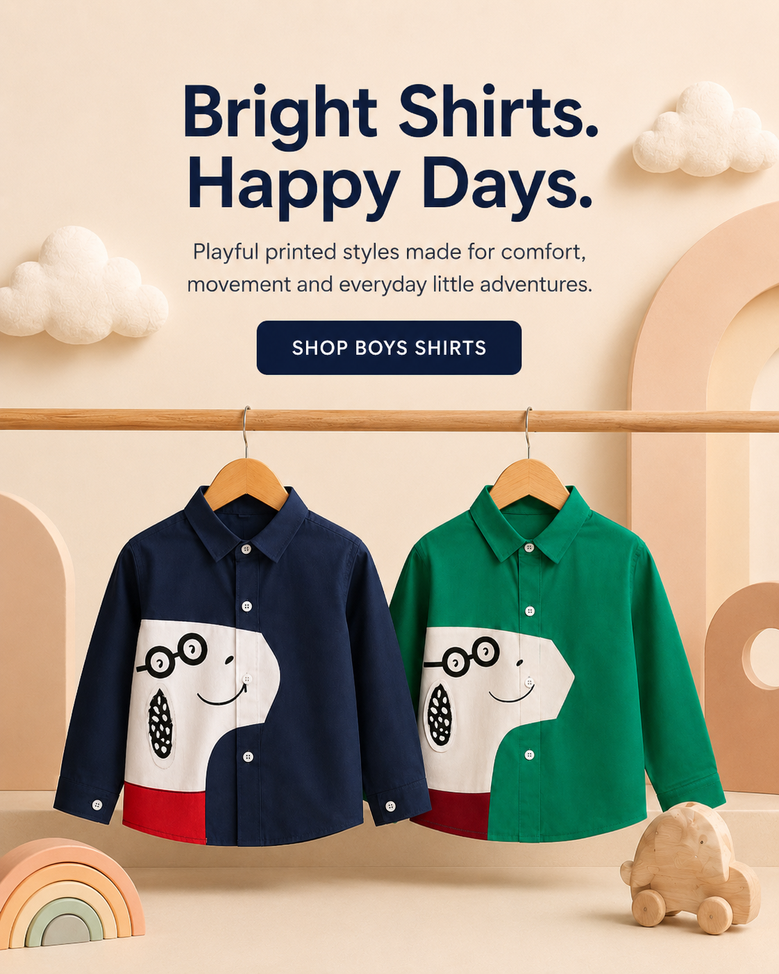 Two children's long-sleeve button-front shirts hang on a wooden rack against a warm beige background with decorative clouds and pastel shapes. The left shirt is navy blue with a white graphic panel and red lower panel; the right shirt is green with a white graphic panel and red lower panel.
